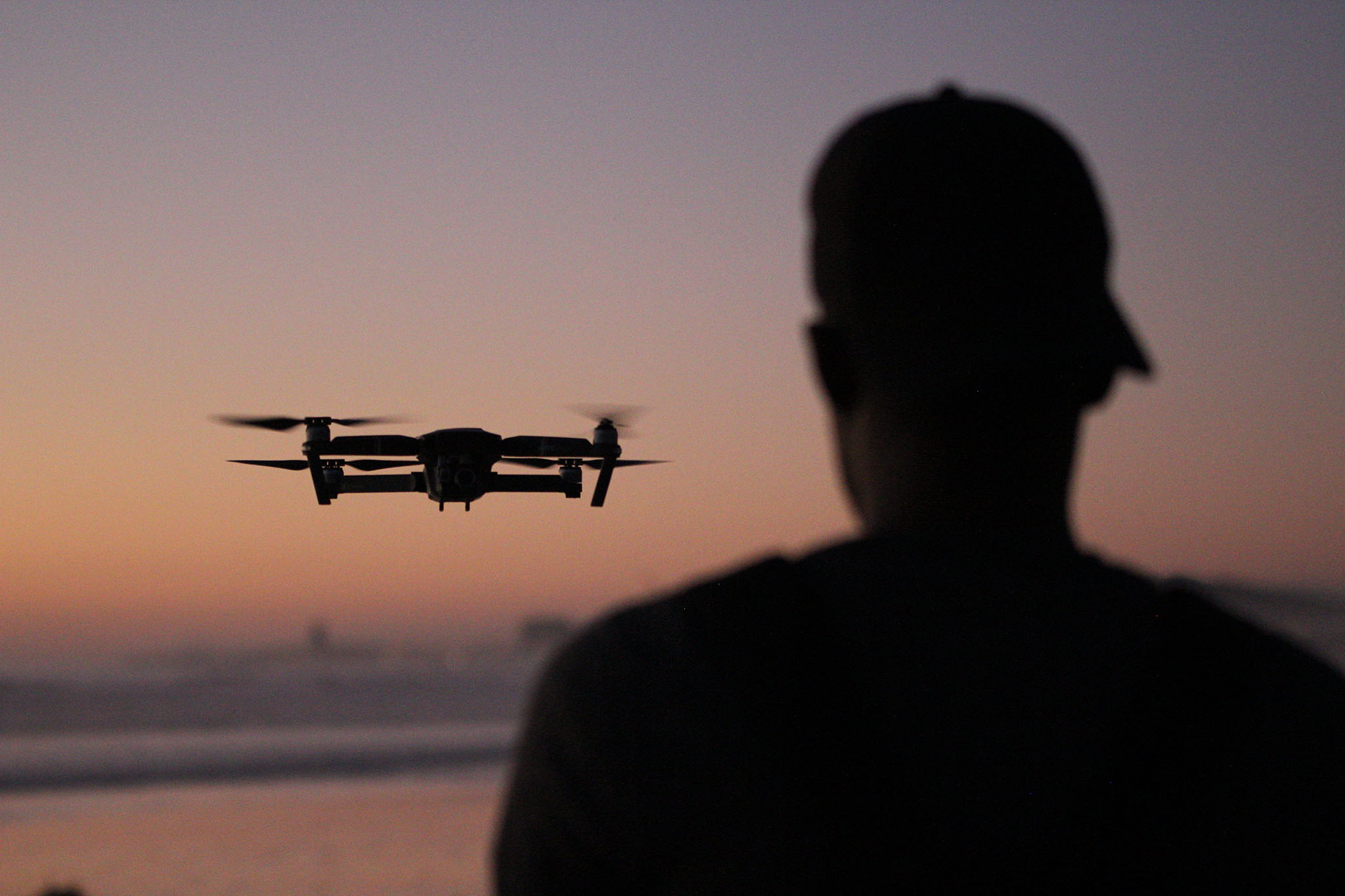 flying a drone at the beach at sunset